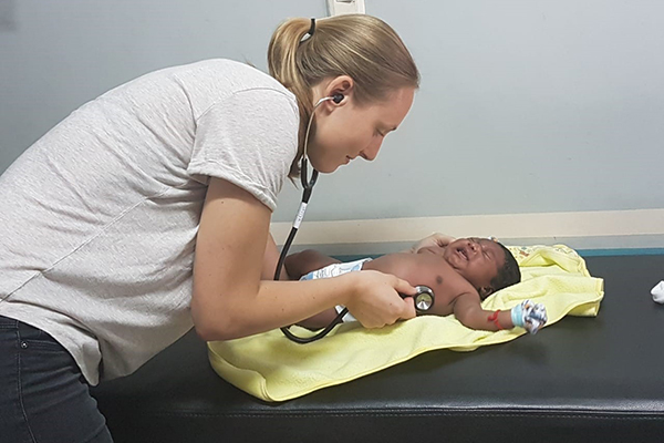 Maastricht University medicine student inspects a baby during her clinical internship in Ecuador