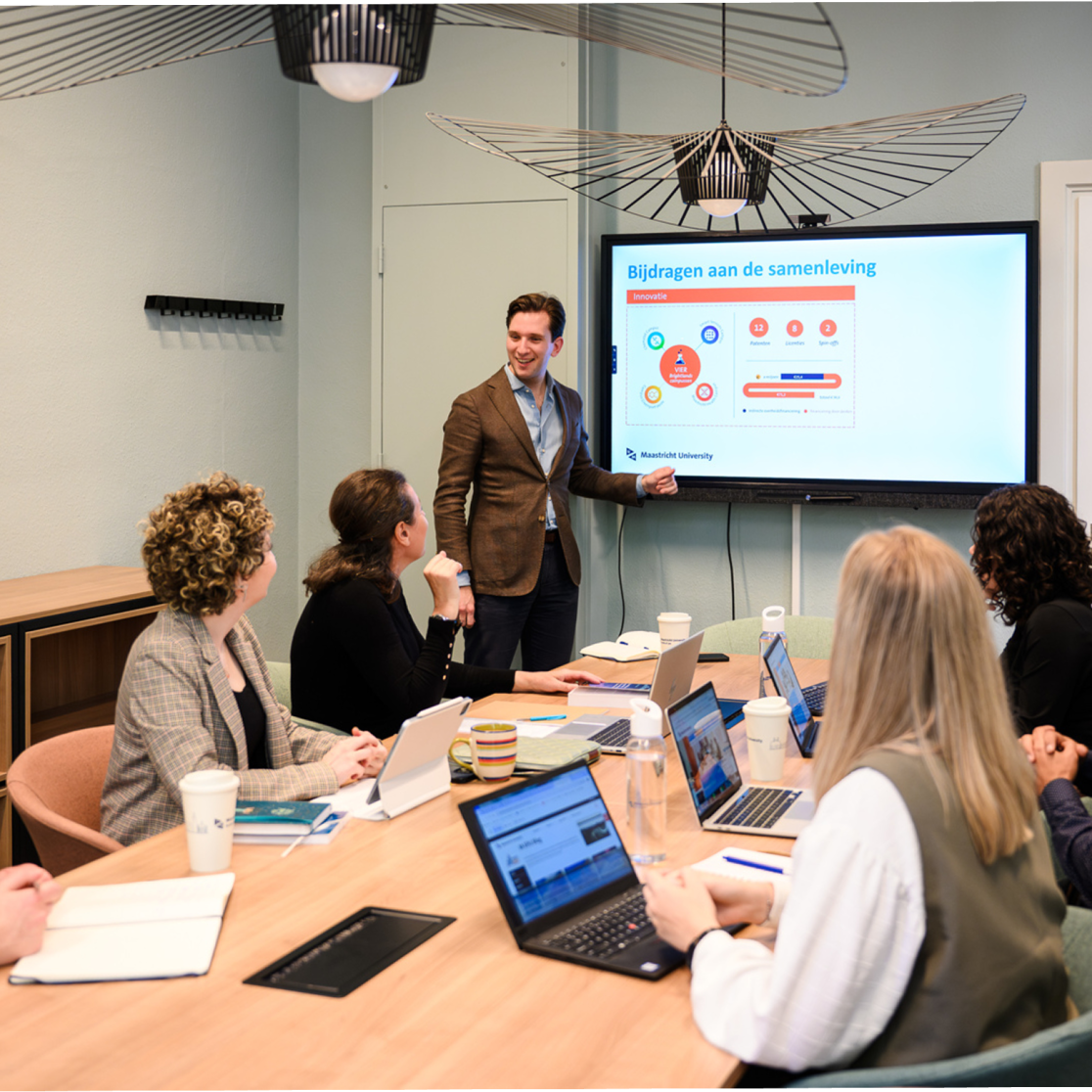 UM Academy: professionals around a table, watching a presentation