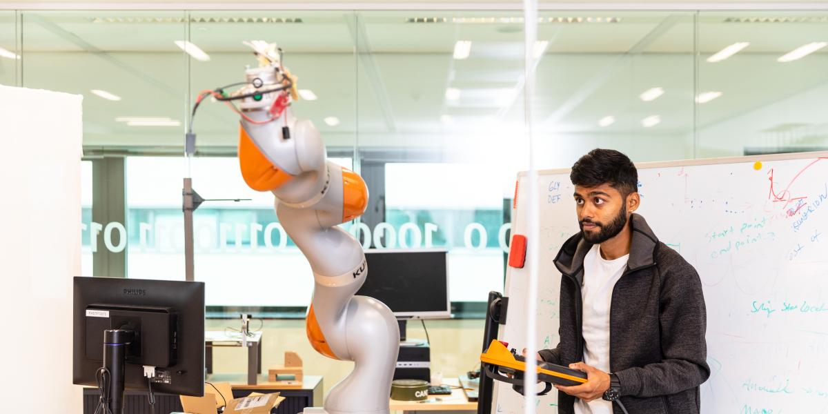 Guy working with robot arm