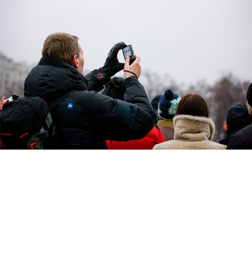 Photo: young man is filming a demonstration with his mobile phone