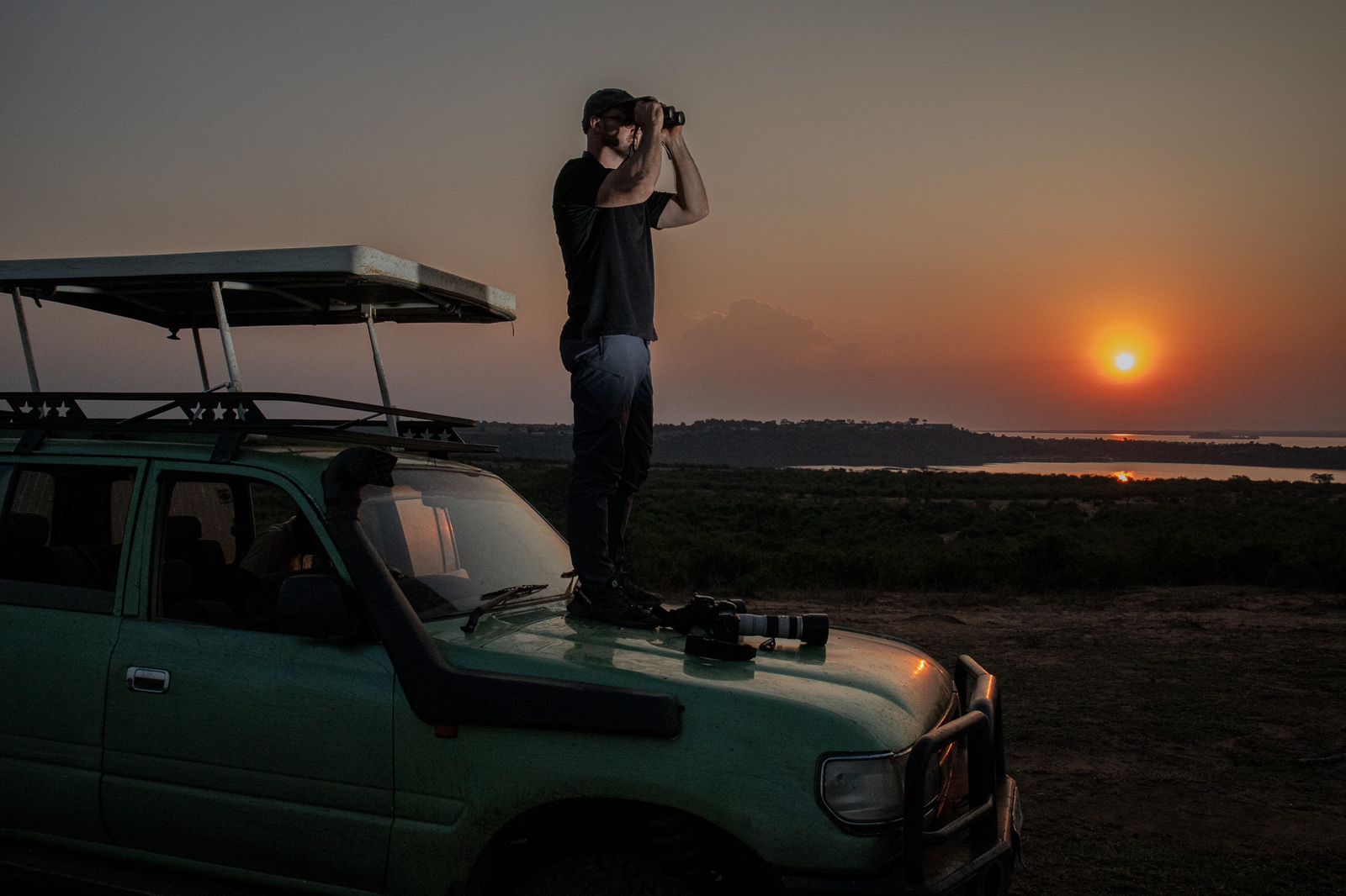 Christopher O'Bryan in African dusk standing on his truck