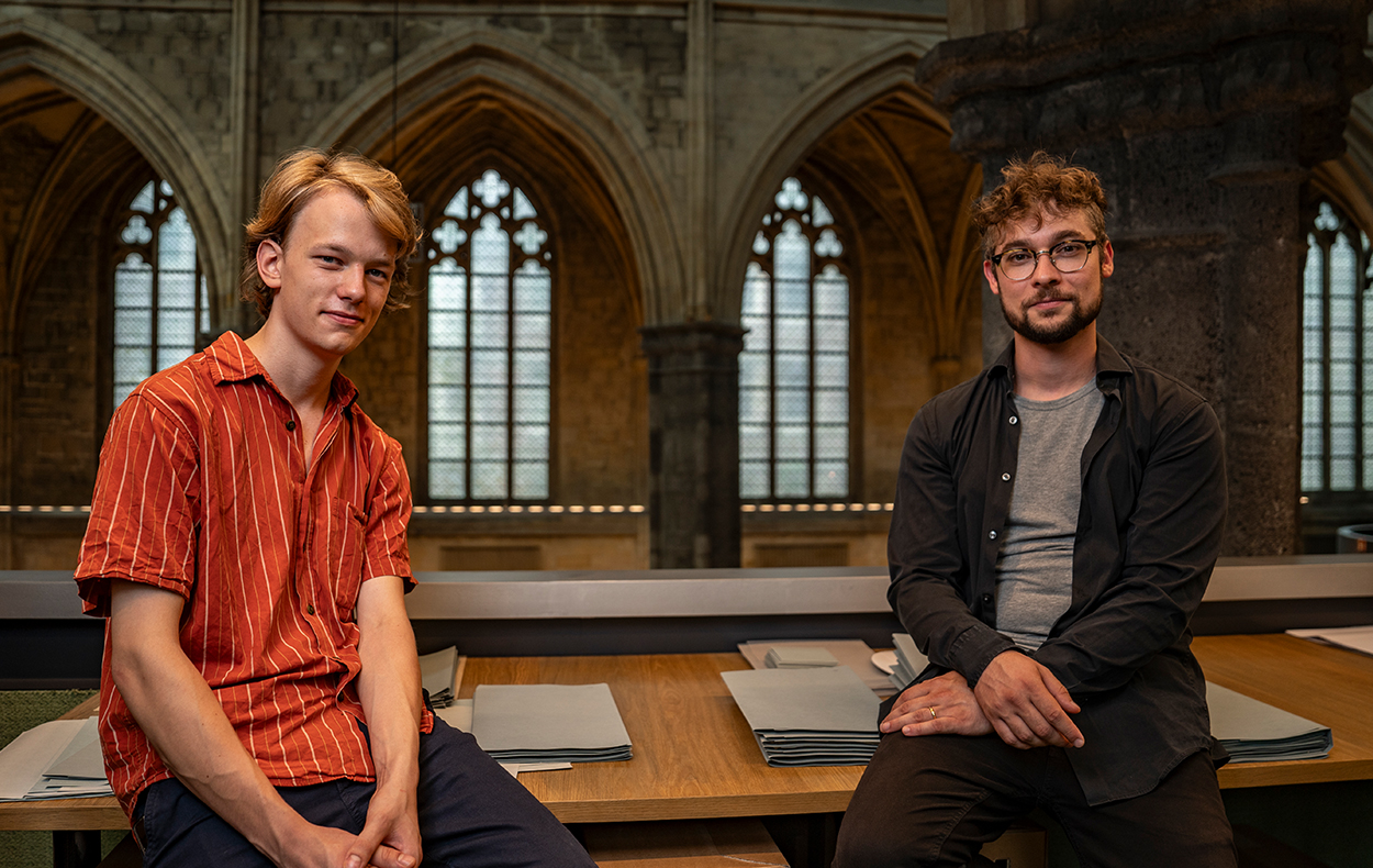 Two guys sitting on desk