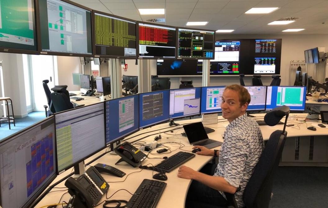 Jacco de Vries in a control room full of tv-screens at het LHCB laboratory at CERN