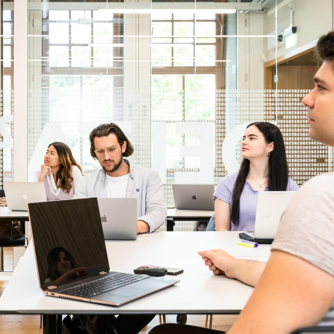 Quality assurance in education: students in class listening and on their laptop