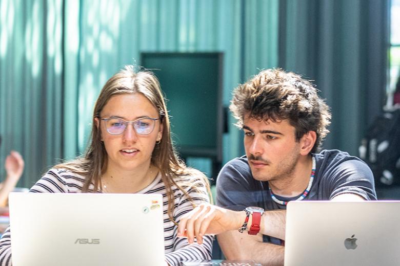 Two students working on their laptop